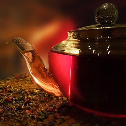 a glass teapot full of a red colored tea