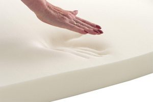woman touching a memory foam mattress topper
