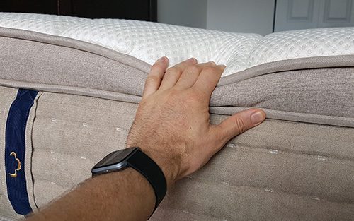 hand pushing the side of the Dreamcloud mattress to show the supports