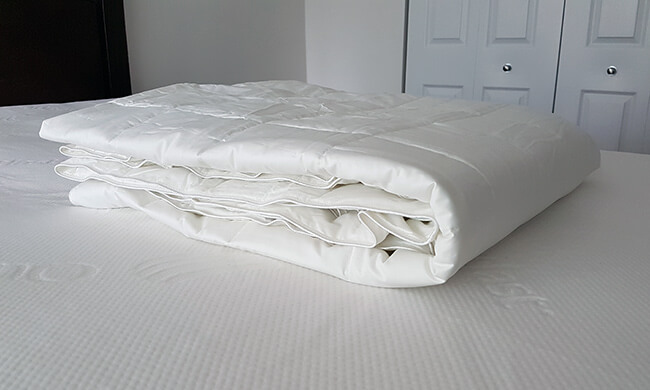 slumbercloud cooling mattress pad and comforter on top of a bed