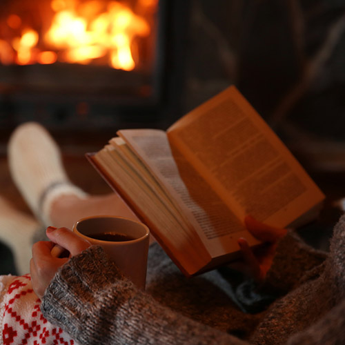 woman relaxing by reading a book at night