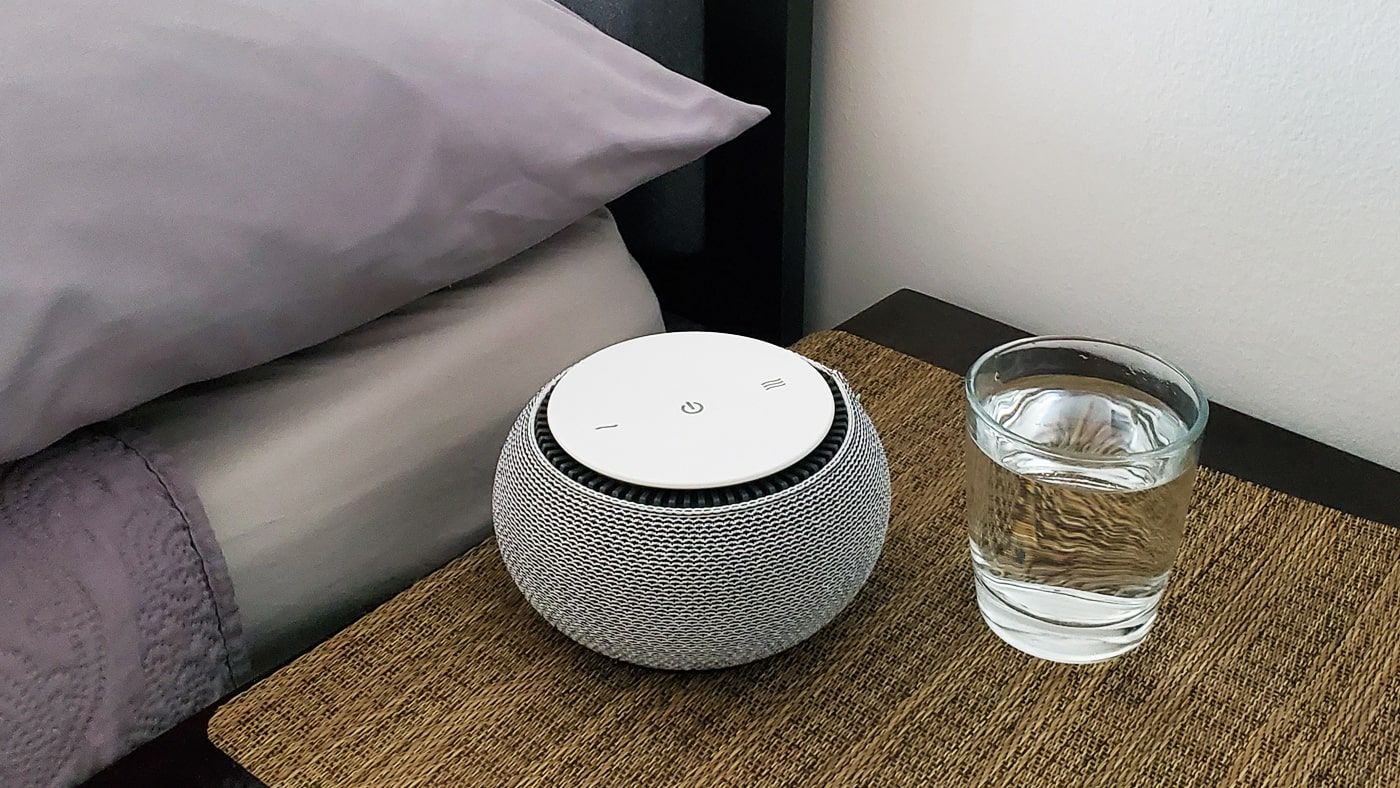 Snooz white noise machine next to glass of water