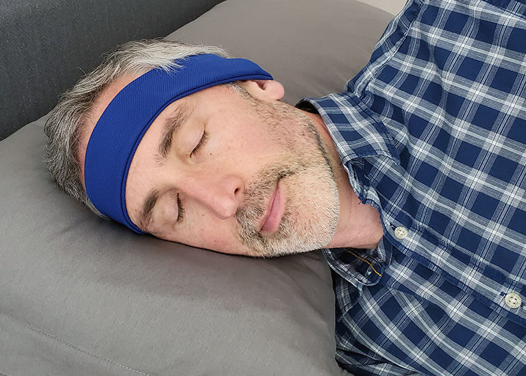 man wearing the sleepphones while lying on his side