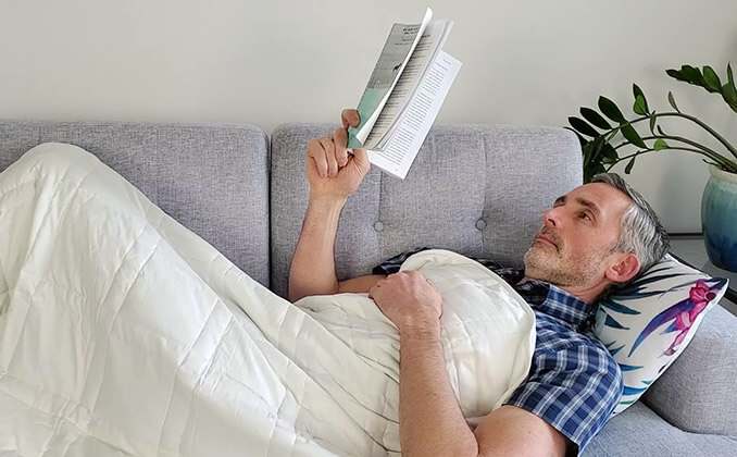 man on the sofa under the Baloo weighted blanket