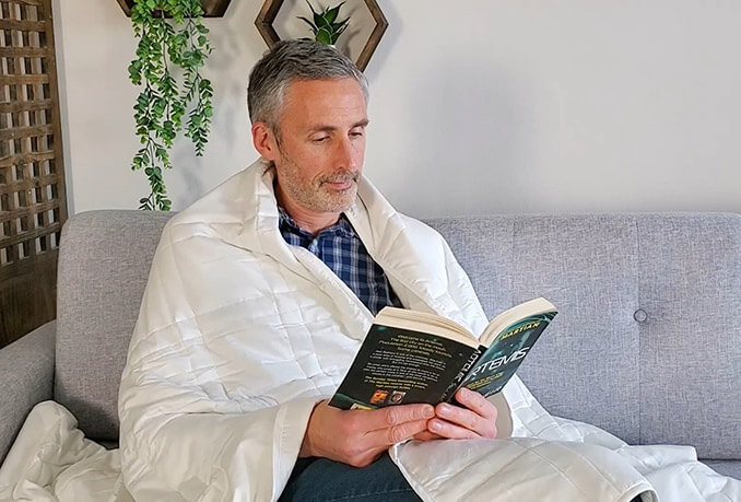 photo of a man using a queen size baloo weighted blanket