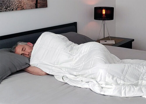 A man sleeping under the Baloo weighted blanket