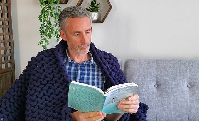 Man reading while using the Bearaby Napper