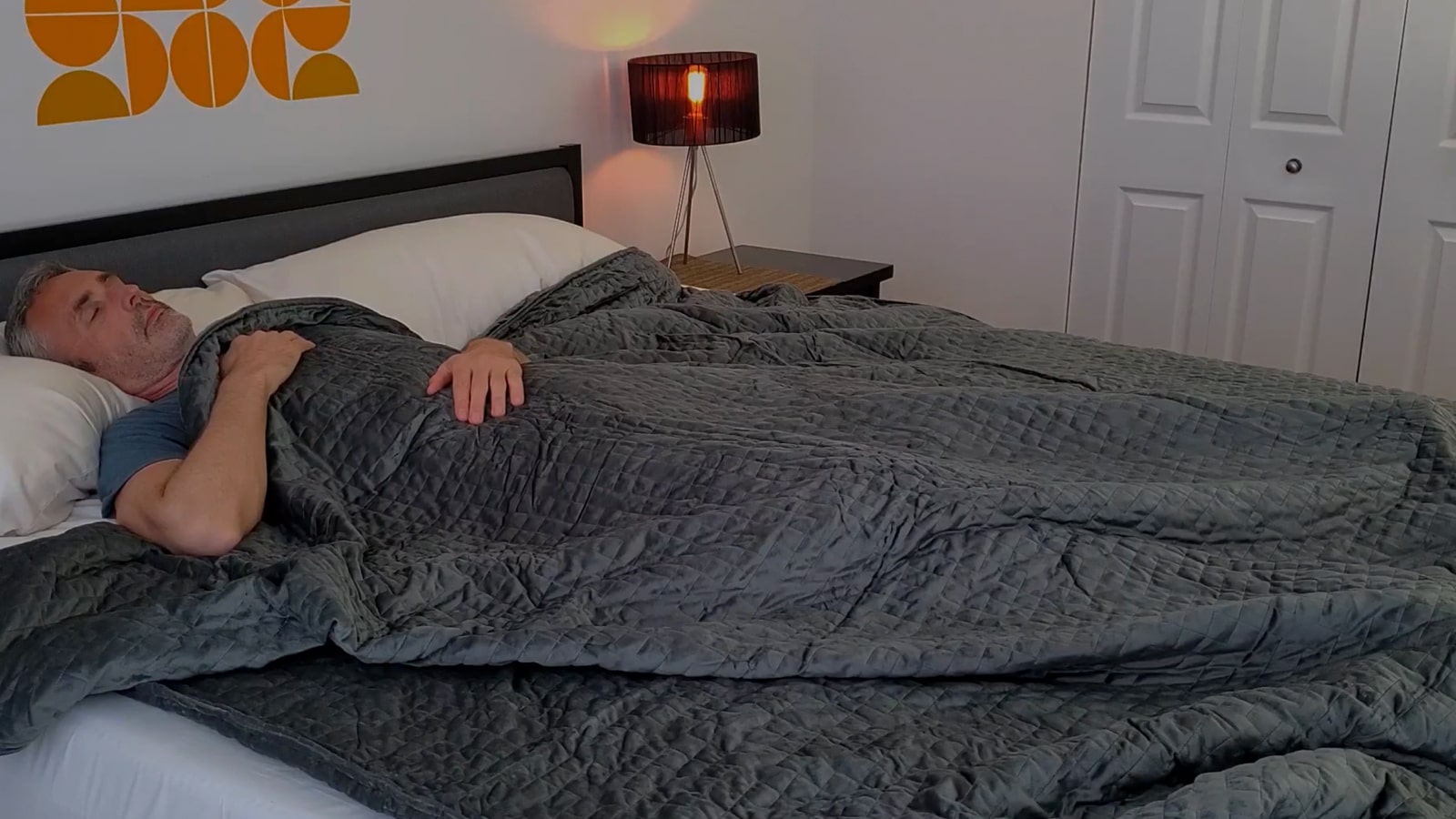 man using the queen size Gravity blanket in bed