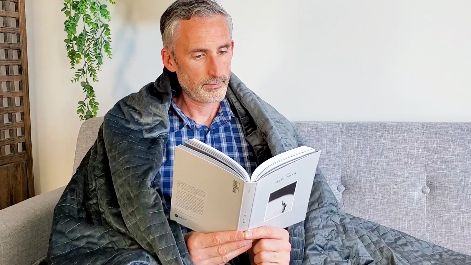 man sitting with the Gravity weighted blanket 