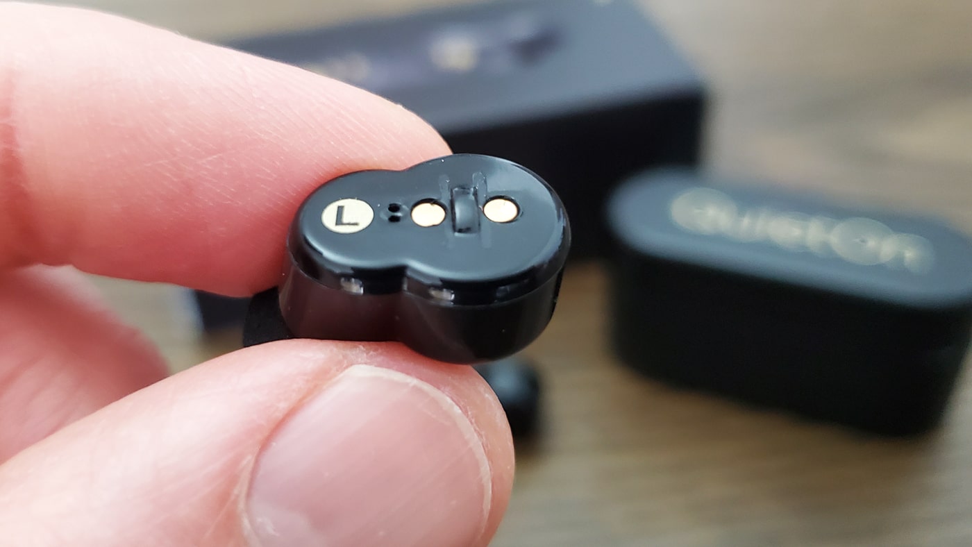 close up photo of the button on the  left quieton earbud