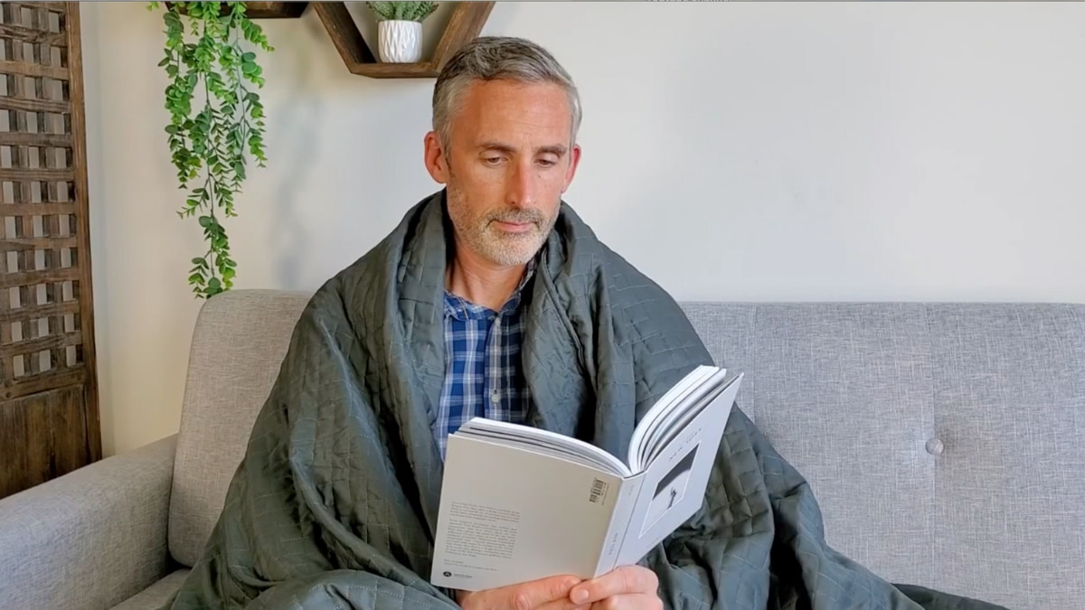 man sitting with the cooling Gravity weighted blanket