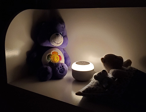 photo of the yogasleep travel mini in a bedroom with the nightlight turned on