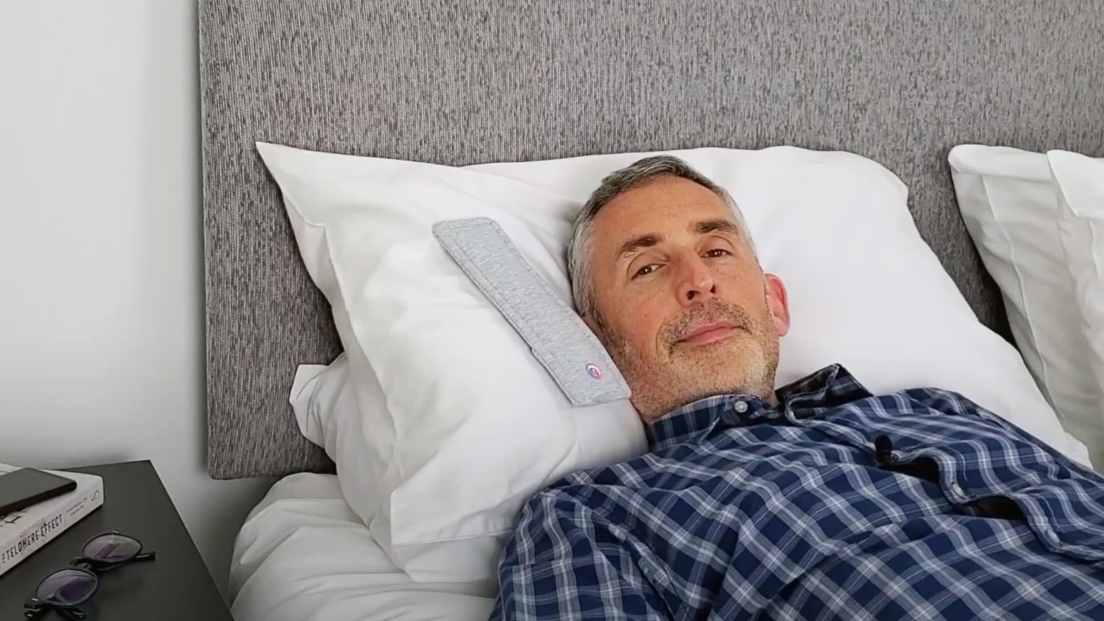 man demonstrating the Drowsie pillow speaker