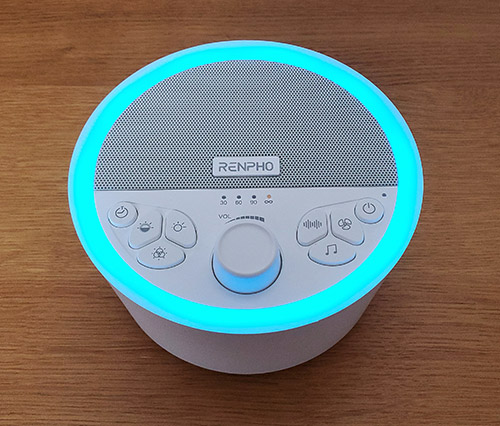 renpho sound machine on a table with the night light on light blue