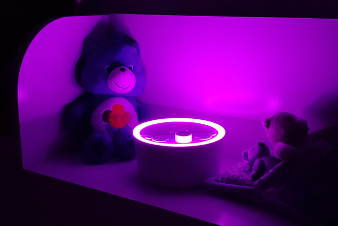 renpho sound machine night light on the purple setting in a bedroom at night