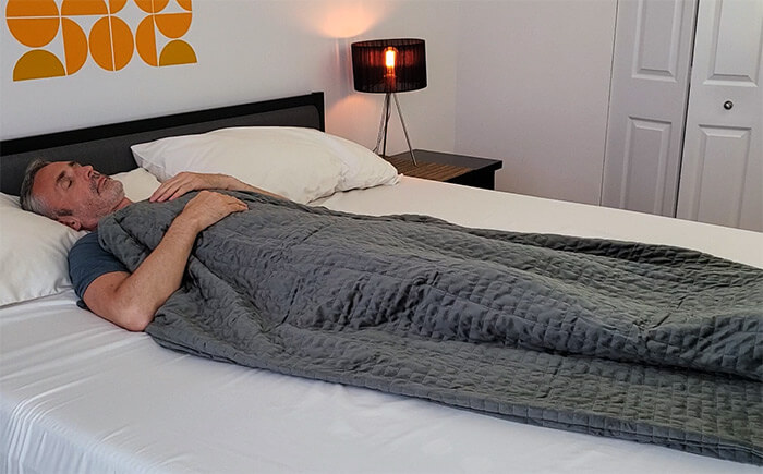 photo of a man sleeping under the Gravity weighted blanket