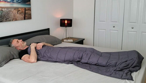 man sleeping under the YNM weighted blanket