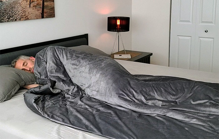 photo of a man sleeping under the Luxome weighted blanket