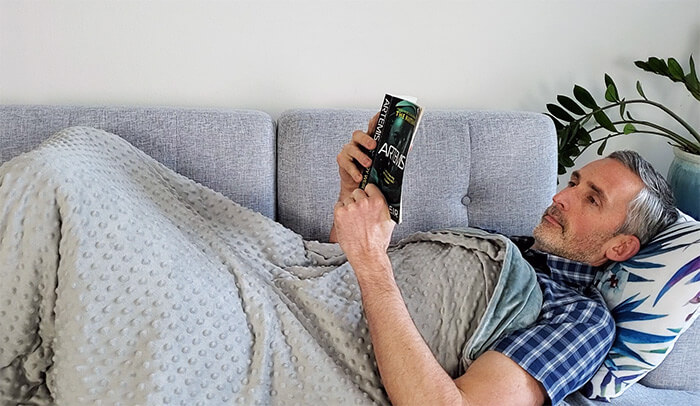 man on a sofa with the quility weighted blanket