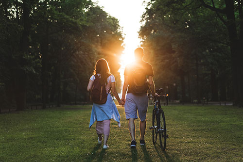 man and woman walking outside at sunset