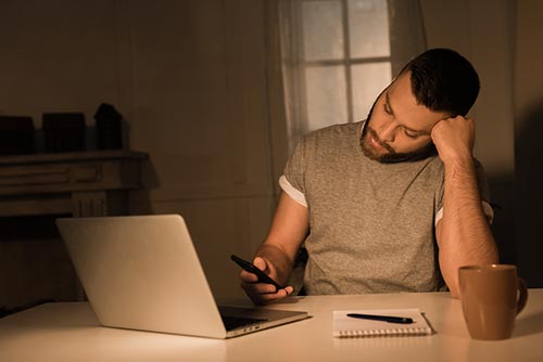 man using a computer and phone