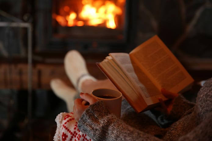 woman reading a book and drinking tea