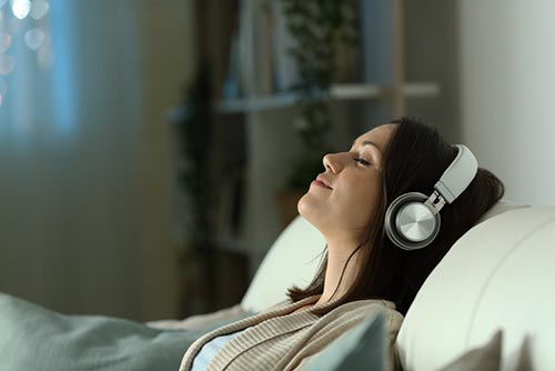 woman listening to music on the sofa