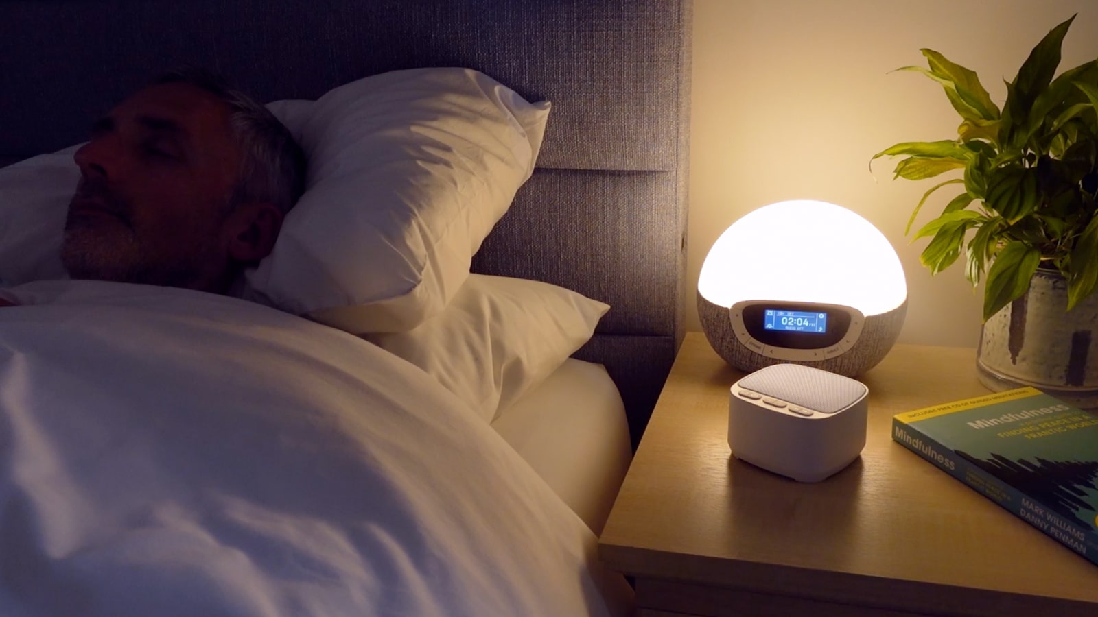 Magicteam sound machine on a nightstand in a dark bedroom