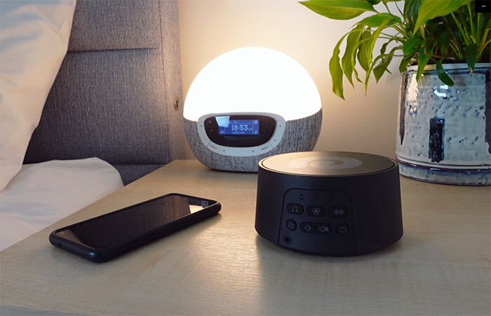 dreamegg d3 pro on a nightstand next to a lamp, plant and phone