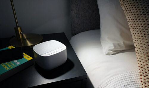 magicteam white noise machine on a nightstand in a dark room