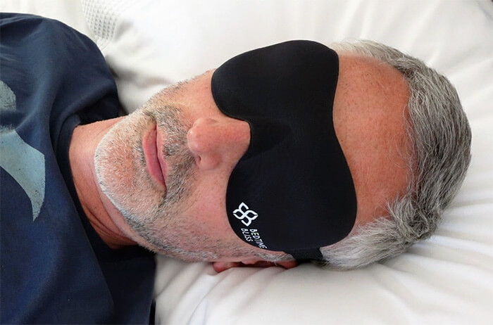 Man sleeping while wearing the Bedtime Bliss sleep mask