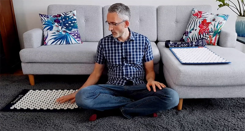 photo of a man (the article author Ethan Green) touching a spoonk acupressure mat