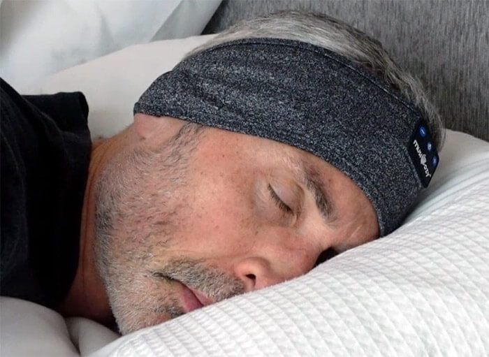 photo of a man in bed using the Musicozy headphones