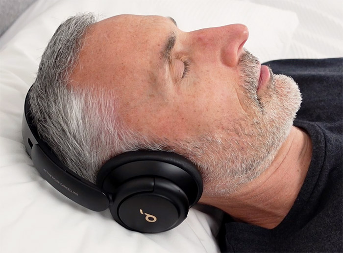 photo of a man using the Soundcore Life Q30 headphones in bed