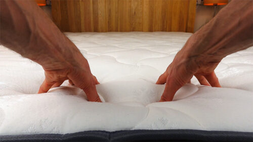 hands pressing down into the top layers of the Inofia mattress