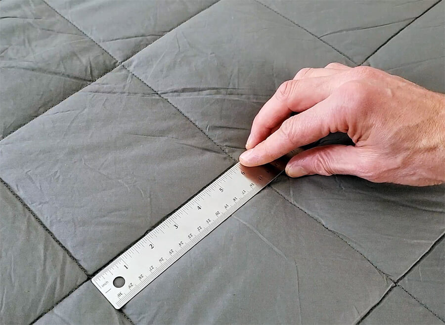 hand holding a ruler to show the luxome weighted blanket's pocket size as 6 inches