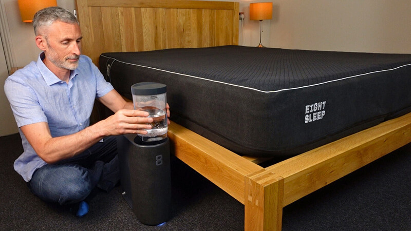 man setting up the Eight Sleep Pod Cover 3 in a bedroom