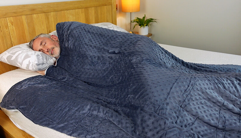 Man sleeping under the Cosi Home weighted blanket