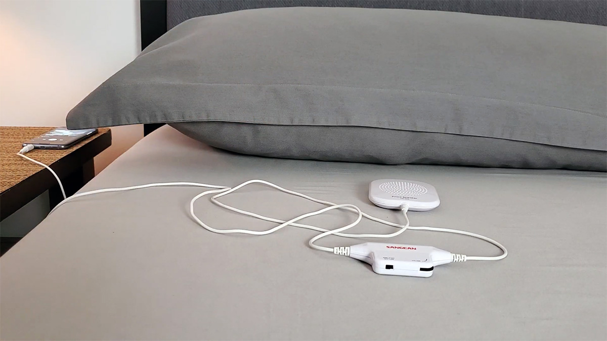 photo of the sangean ps-300 pillow speaker on a bed and plugged into a phone