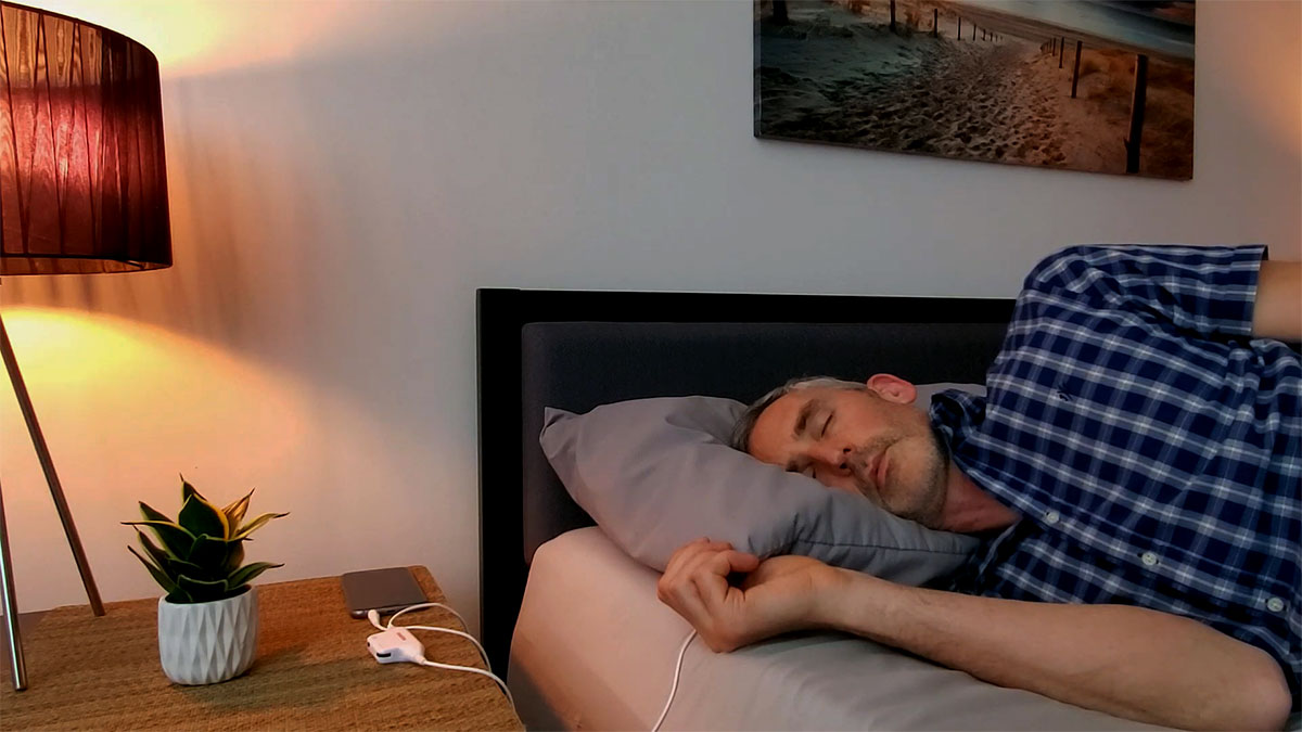 man sleeping with Sangean pillow speaker