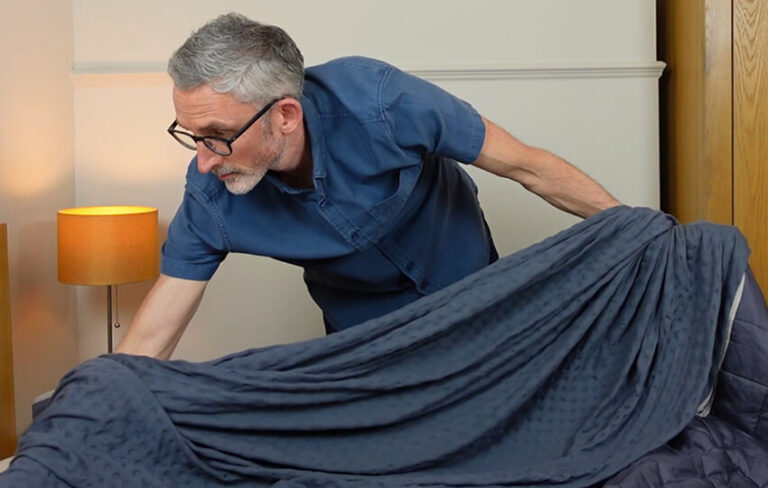 man putting a duvet cover on a weighted blanket