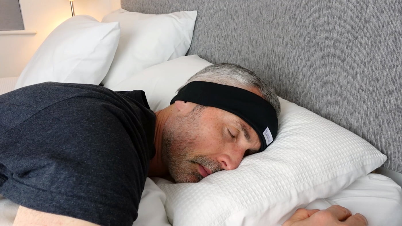 man sleeping on his side wearing the AcousticSheep Sleephones