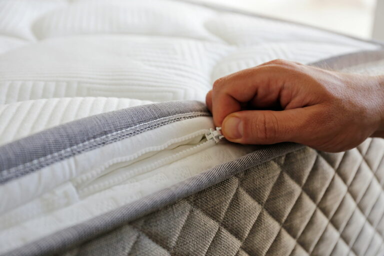 person unzipping a mattress topper close up
