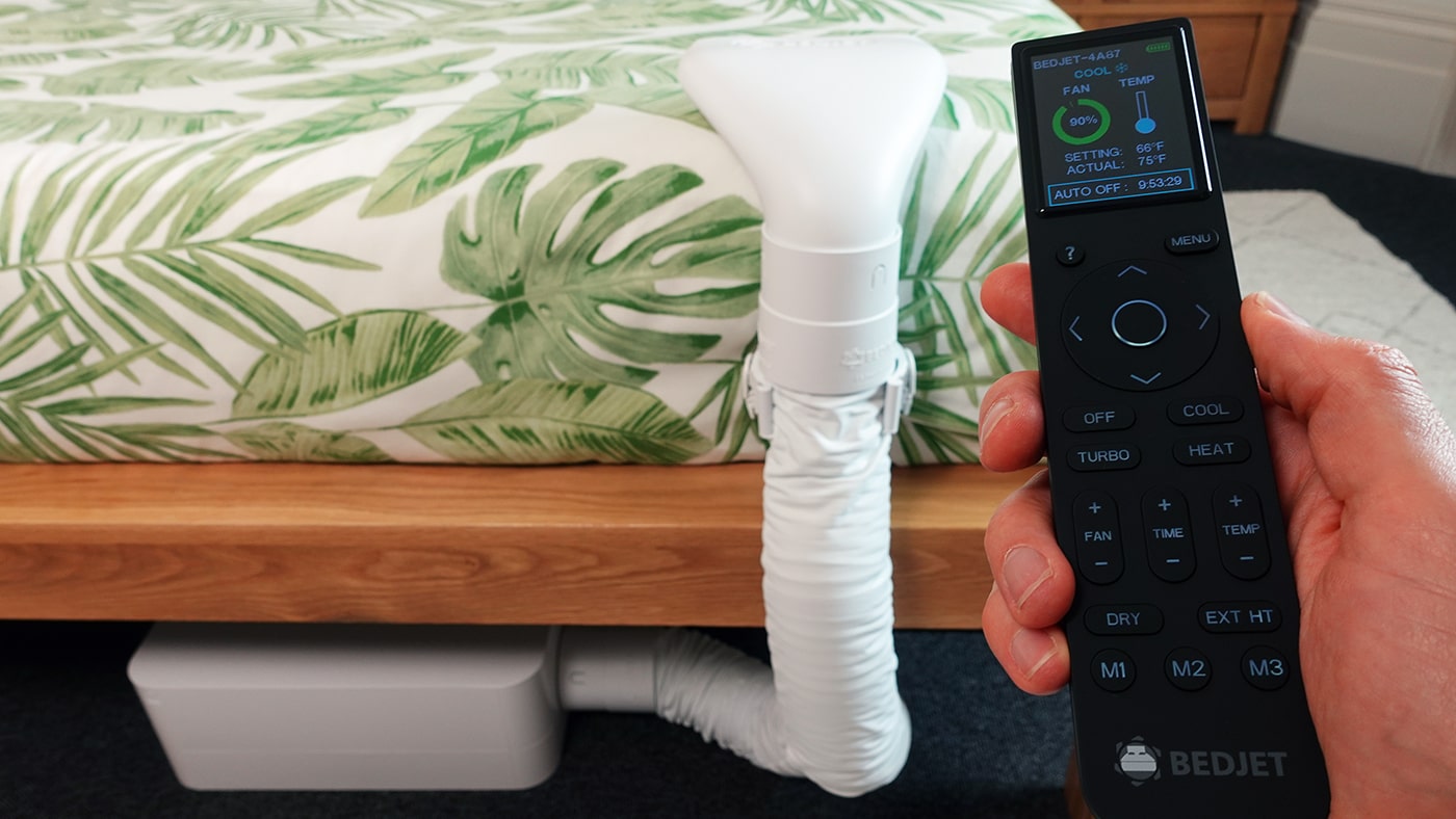 Bedjet 3 set up in a bedroom with the remote control close up