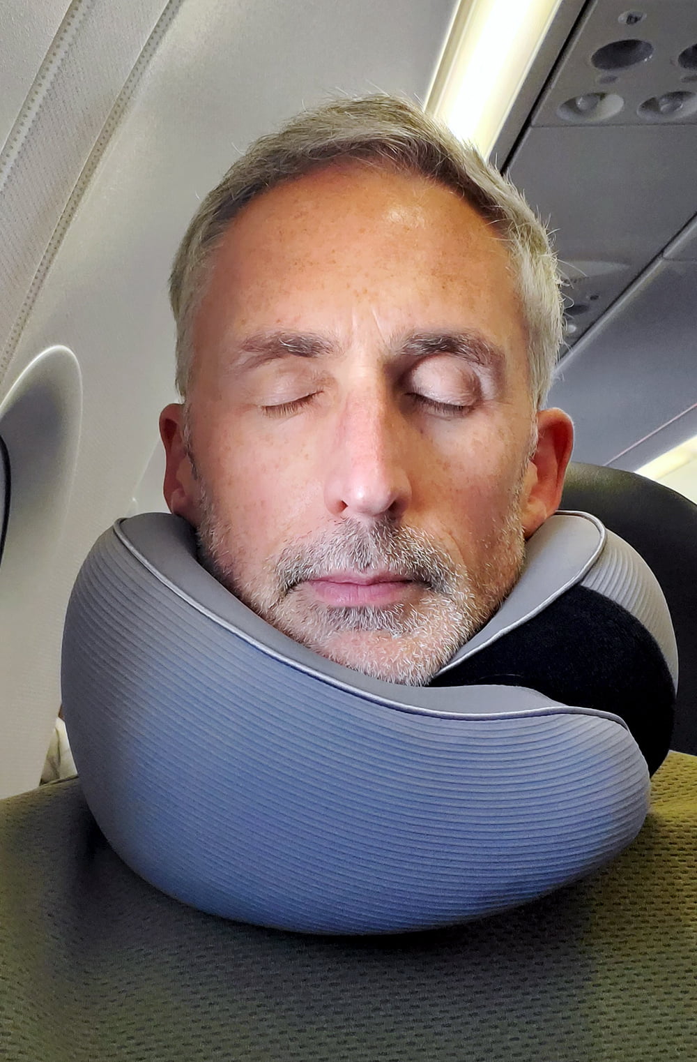 man using AYHome travel pillow on a plane