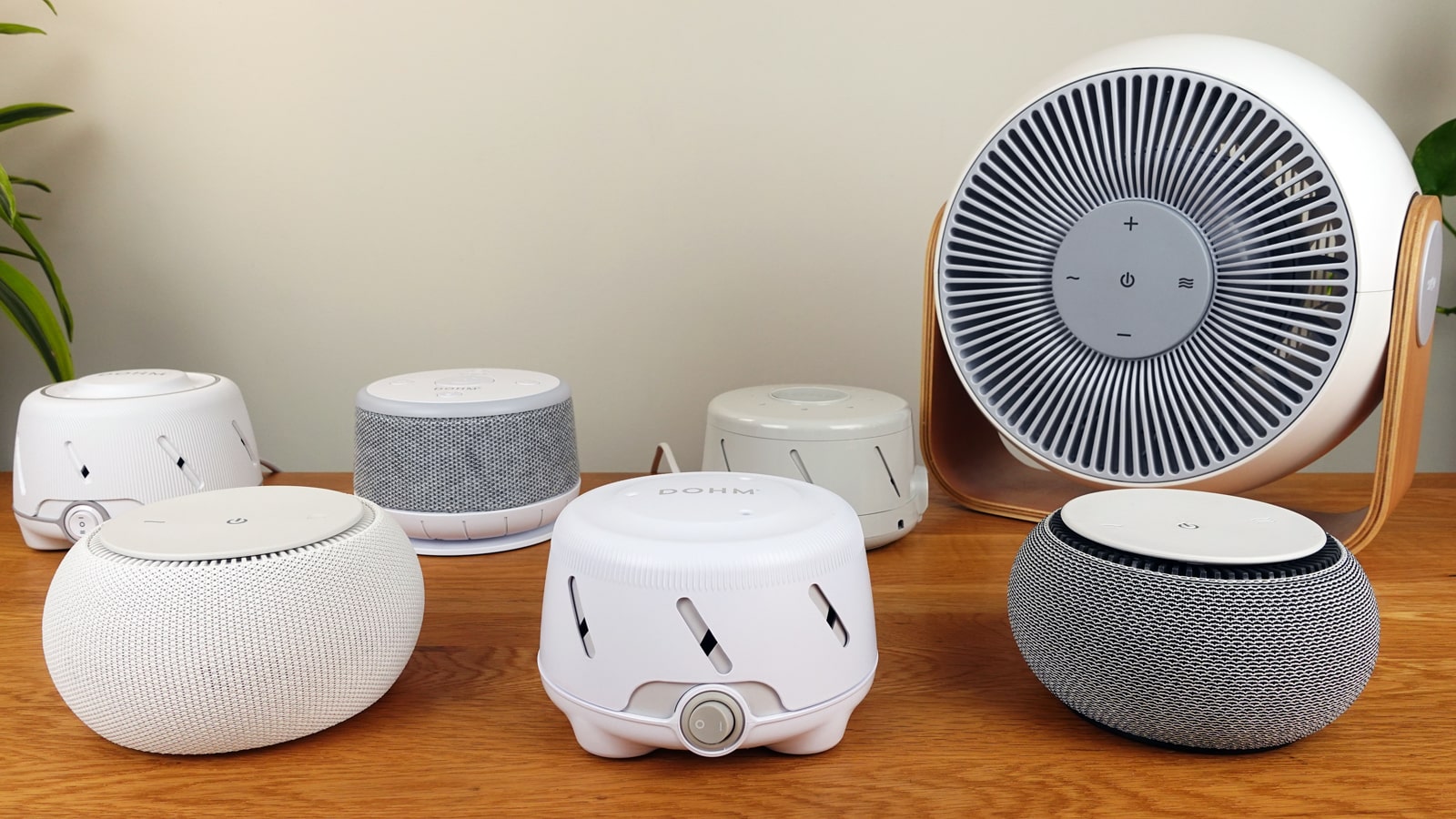 Snooz Breez, Original and Pro, Yogasleep Dohm, Dohm Uno, Dohm Classic, and Dohm nova white noise machines on a table.