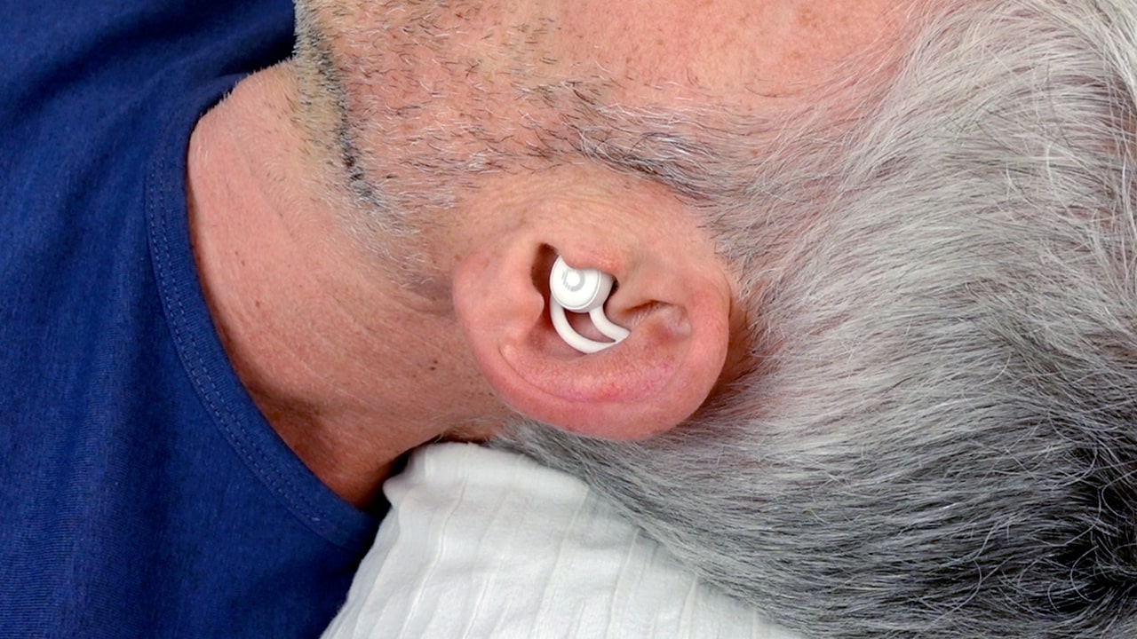 Close up photo of man wearing Ozlo sleep buds