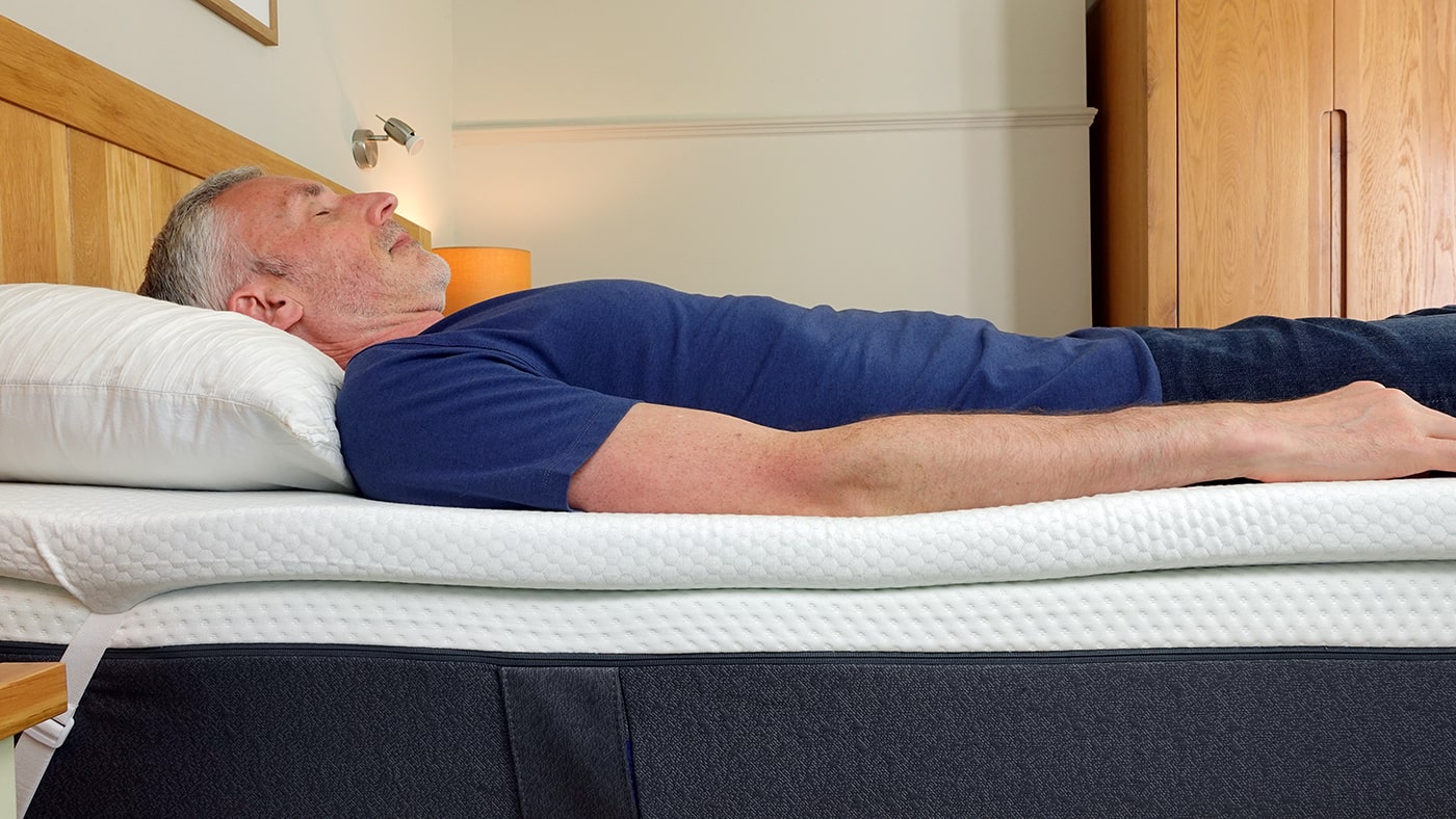 man sleeping on the Panda memory foam mattress topper