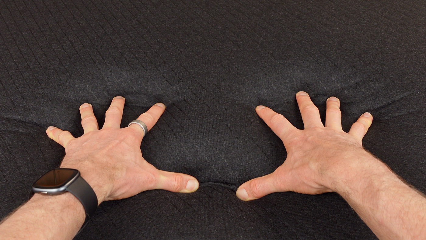 hands pressing into the Eight Sleep Pod 5 mattress pad