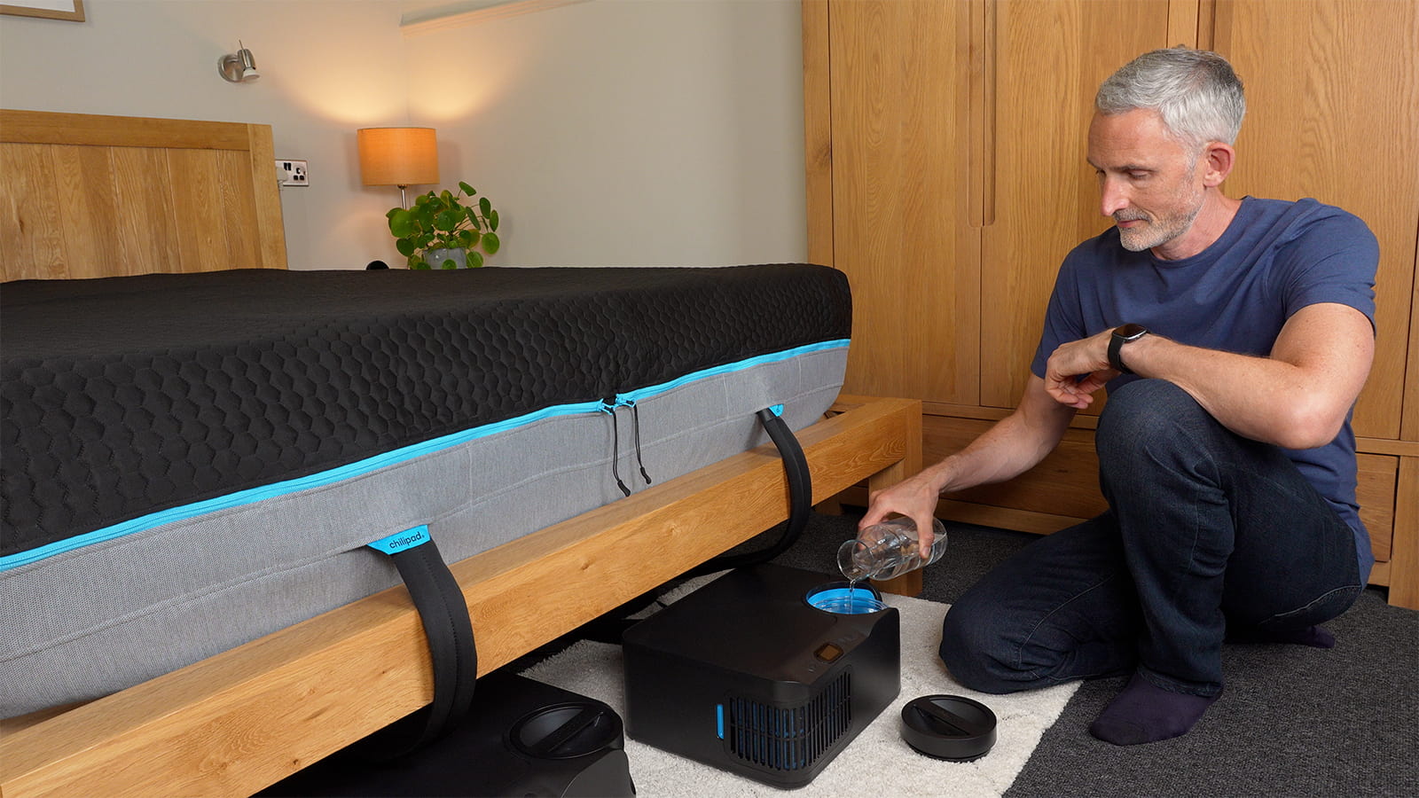 man filling the water tank of the Chilipad 2.0 cooling mattress pad